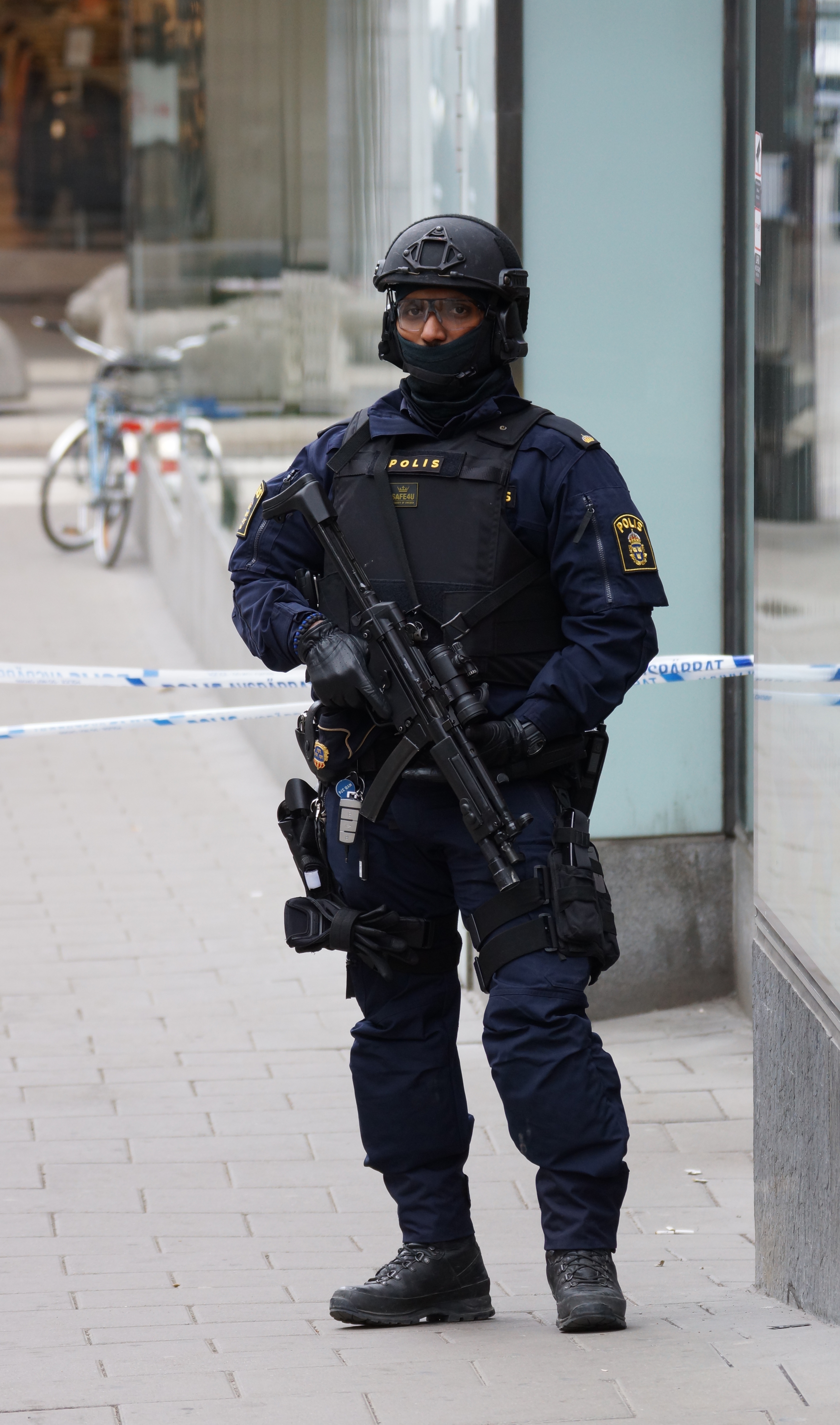 A Swedish tactical police officer standing behind a cordon in Stockholm